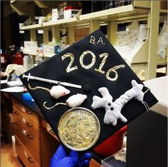 a graduation cap that has been decorated with gold and silver glitters, is being held by a person