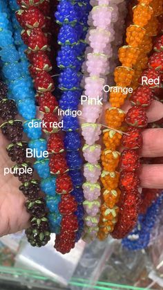 several different colors of beads are being held by someone's hand in front of them