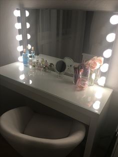 a vanity with lighted lights and flowers on it