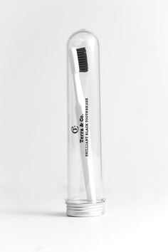 a white toothbrush in a clear tube