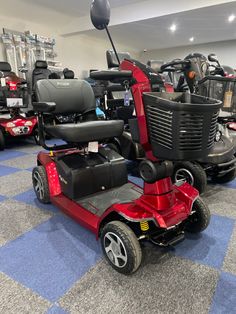 three wheeled scooters are lined up in a room with other scooters