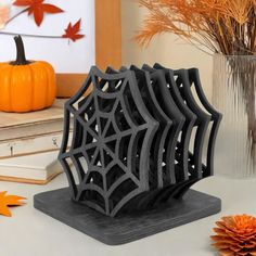 a spider web bookend sitting on top of a table next to a vase filled with orange flowers