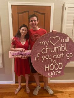 two people standing next to each other holding a sign that says, my love will crumb if you don't go hoo whine