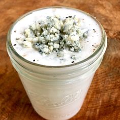 a glass jar filled with yogurt sitting on top of a wooden table