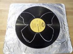 an old record on tinfoil with a flower design in the middle and black vinyl