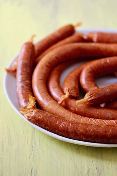 a white plate topped with lots of cooked hot dogs