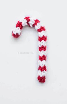 a crocheted candy cane sitting on top of a white surface