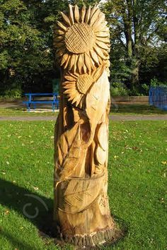 a carved wooden statue in the middle of a park