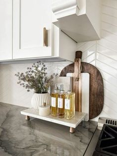 two bottles of liquid sitting on top of a counter next to a cutting board and utensils