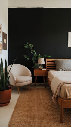 a bed room with a neatly made bed next to a chair and potted plant