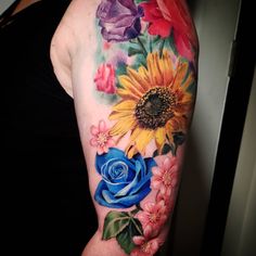 a woman with a sunflower and roses tattoo on her arm