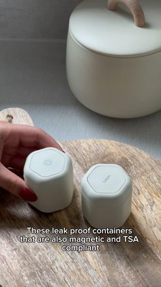 a woman's hand is pressing buttons on a wooden board with the words, these talk proof containers that are automatic and tsa