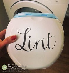 a person is pointing at the lid of a toilet that says lint on it