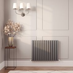 a radiator in the corner of a room next to a vase with flowers