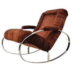 a rocking chair with a brown cushion and chrome frame, on a white background photo