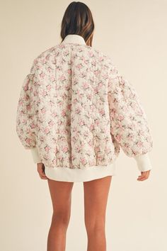 Oversized floral print bomber jacket Quilted design Zipper accents Lined Zip up front closure Pearl dangle zipper detail Cinched fitted sleeve cuffs, and neck details Fitted jacket bottom Off white with pink floral print True to size Model is wearing a size small Neck Details, Fitted Jacket, Oversized Jacket, Printed Quilt, Workout Jacket, Zipper Detail, Club Outfits, Quilted Jacket, Quilting Designs