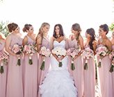 a bride and her bridal party in pink dresses