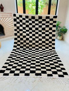 a black and white checkered blanket sitting on top of a floor next to a fireplace