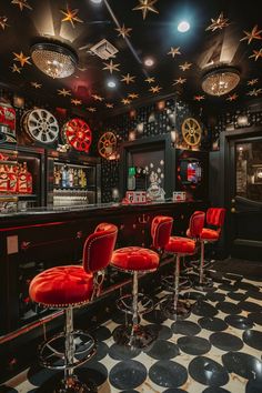 a bar with red chairs and gold stars on the ceiling is decorated in black and white checkered tile