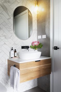 a bathroom sink with a mirror above it and a towel hanging on the wall next to it