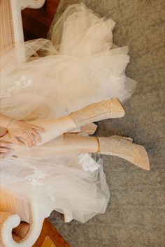 a woman in white dress and high heels laying on the floor