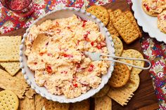 a bowl of dip surrounded by crackers and crackers