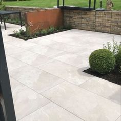 an outdoor patio area with stone walls and plants in the center, surrounded by shrubbery