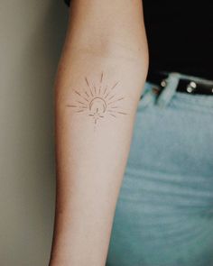 a woman's arm with a sun and moon tattoo on the left side of her arm