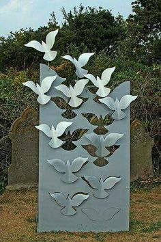 a metal sculpture with white birds on it