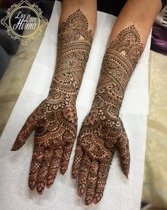 two hands with henna tattoos on them