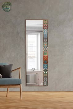 a living room with a chair, window and wall hanging on the wall next to it