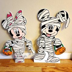 two mickey mouse cut outs are sitting on the floor next to each other with halloween decorations around them