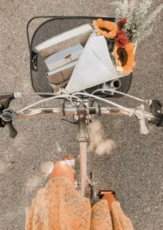 a person on a bicycle with some items in the basket and their feet propped up against the handlebars