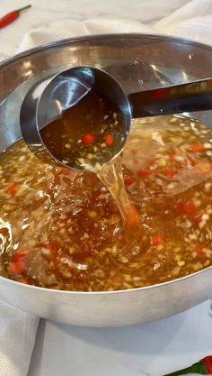 a pot full of soup being stirred with a ladle