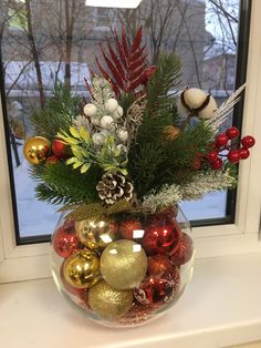 a glass bowl filled with ornaments on top of a window sill