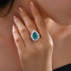 These beautiful ring feature a halo pear cut paraiba, sure to add a splash of color to any look. Main Stone Type: Lab-Created Paraiba Main Stone Shape: Pear Cut Main Stone Size: 10 x 14mm Main Stone Quantity: 1 Main Stone Setting: 4 Prong Metal: 925 Sterling Silver Rhodium Finish: Yes Paraiba Tourmaline Engagement Ring, Tourmaline Engagement Ring, Pear Cut Engagement Rings, Green Stone Rings, Lab Diamond Engagement Ring, Paraiba Tourmaline, Pear Engagement Ring, Creating Jewelry, Green Gemstones