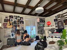 two women sitting on the floor in a room with lots of clutter and pictures