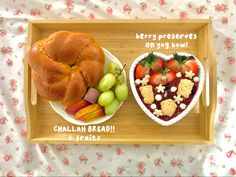 there is a tray with fruit and bread in the shape of a heart on it