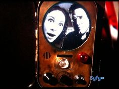 an old fashioned television with two people on it's face and the screen is turned upside down