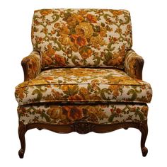 an upholstered chair with floral fabric and wood trimmings on the arms