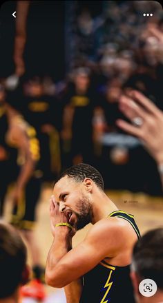 a basketball player holding his hand up to his face