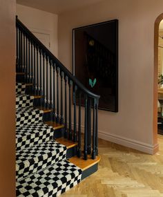 the stairs are decorated with black and white checkered rugs, along with a painting on the wall