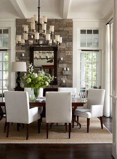 a dining room table with white chairs and a chandelier