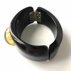 "Item: This is a fabulous black bakelite clamper bangle bracelet with a reverse carved apple juice flower cabochon mounted in the center. It's in excellent condition, has been tested and guaranteed vintage bakelite. Be sure to check our other listings for lots more bakelite jewelry! Measurements: 1 1/4\" wide in front - 2 1/4\" inner oval diameter, 6 3/8\" inner circumference. Condition: 9.5 - Excellent Shipping: US buyers pay $14.95 for Fully Insured USPS Priority Mail with Tracking. Internatio Elegant Bakelite Bracelet Jewelry, Elegant Bakelite Bracelet, Vintage Bakelite Bangle Jewelry, Vintage Bakelite Bangle, Vintage Lucite Bangle Bracelet, Vintage Black Bangle Cuff Bracelet, Vintage Bakelite Bracelet, Retro Bakelite Jewelry, Retro Round Bakelite Jewelry