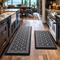 two black and white rugs in the middle of a kitchen with an open floor plan