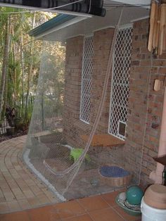 an outdoor shower with a glass door on the outside and brick walls, surrounded by greenery