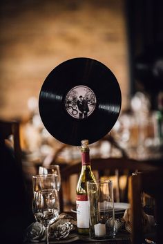 a table topped with a bottle of wine next to glasses and bottles of wine on top of a wooden table