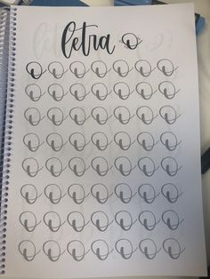 a spiral notebook with the word letra written in cursive writing on it