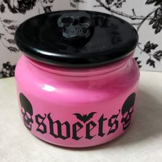 a pink jar with a black lid that says sweetest on the front and skulls on the back