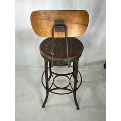 an old fashioned stool with a wooden seat